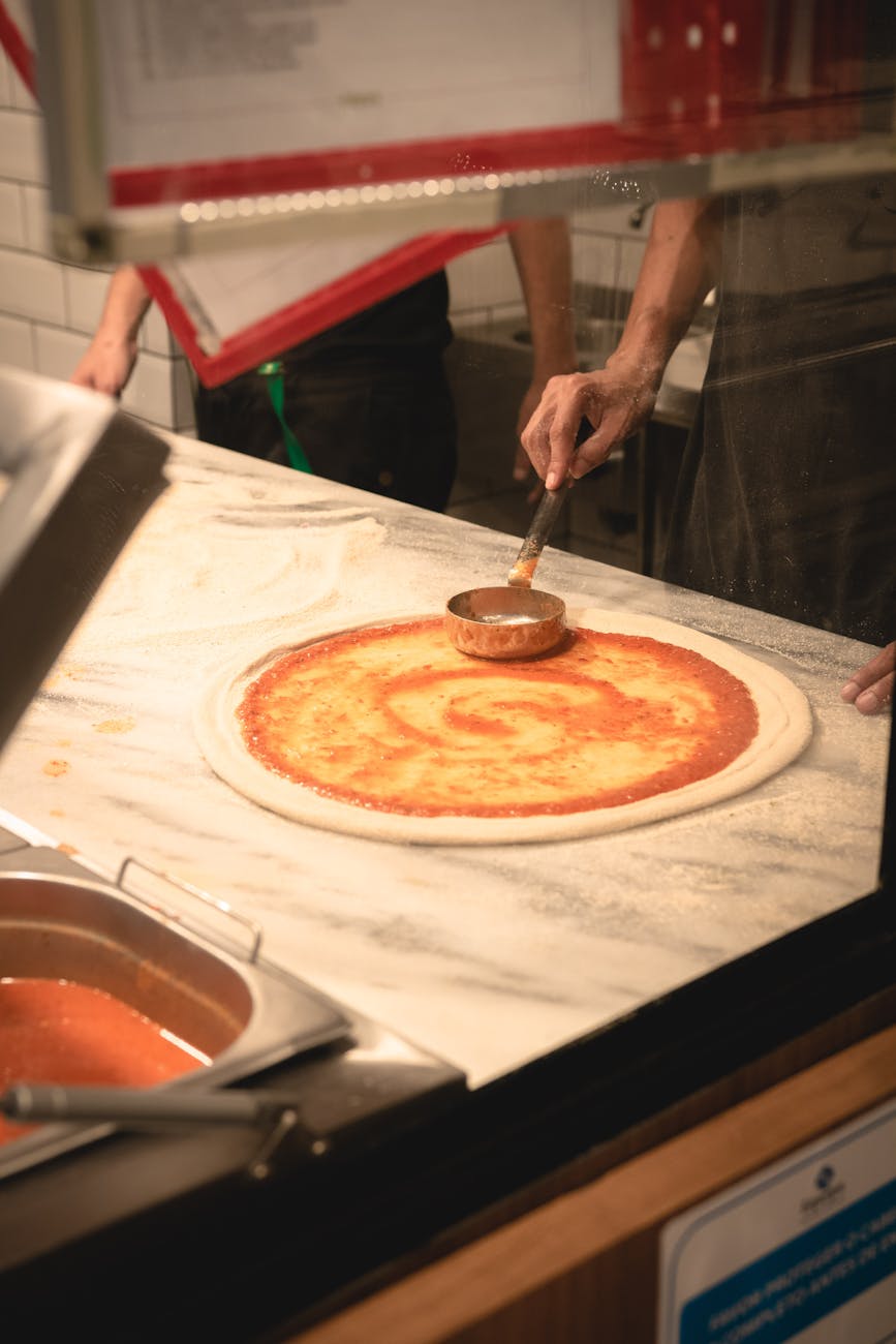 photo of person making a pizza